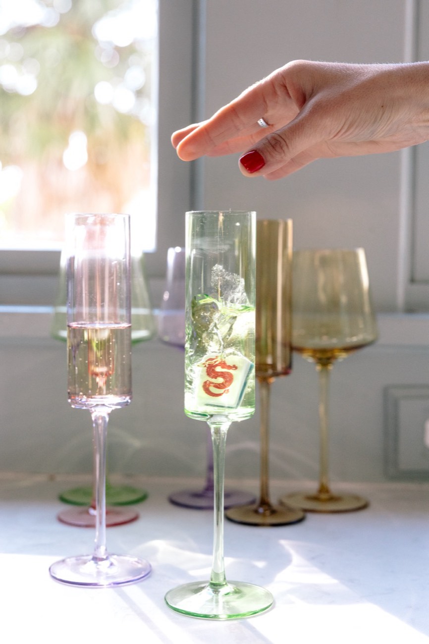 A Mahjong tile sinking in a champagne flute